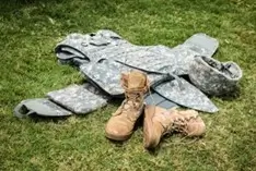 Clothes and shows sprawled out on floor of green grass